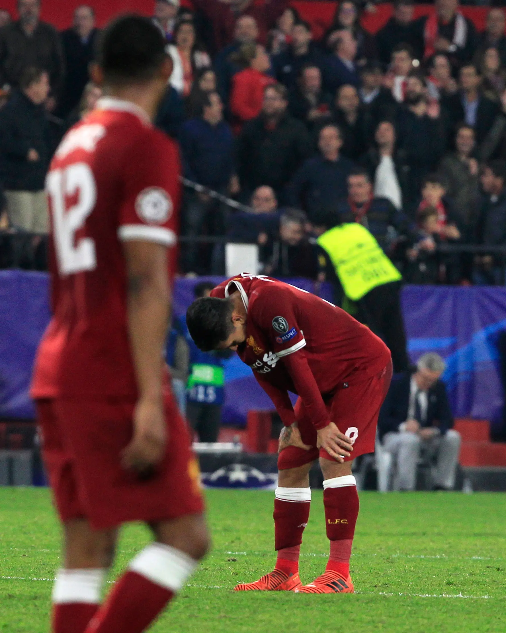 Pemain Liverpool, Roberto Firmino tertunduk di akhir laga kelima Grup E Liga Champions kontra Sevilla di Stadion Ramon Sanchez Pizjuan, Rabu (22/11) (AP/Miguel Morenatti)