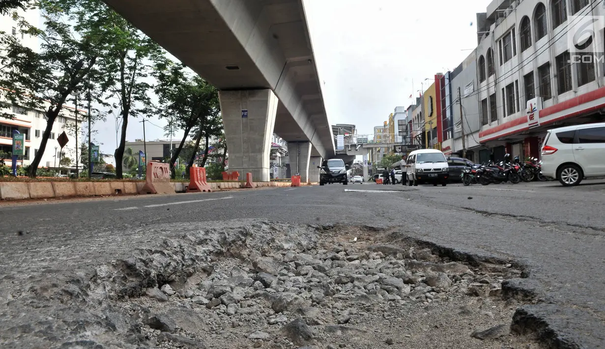 Jalanan rusak di kawasan Kelapa Gading, Jakarta, Rabu (5/9). Kondisi jalan bertambah parah sejak adanya pembangunan proyek LRT yang dapat menyebabkan kecelakaan serta mengancam keselamatan pengendara. (Merdeka.com/Iqbal S. Nugroho)