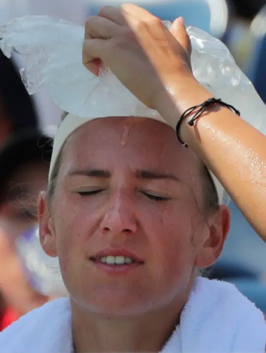 Petenis Belarus, Victoria Azarenka menaruh kantong es di kepalanya karena kepanasan saat istirahat bertanding melawan Daria Gavrilova asal Australia di putaran kedua AS Terbuka, New York, Rabu (29/8). (AP Photo/Frank Franklin II)