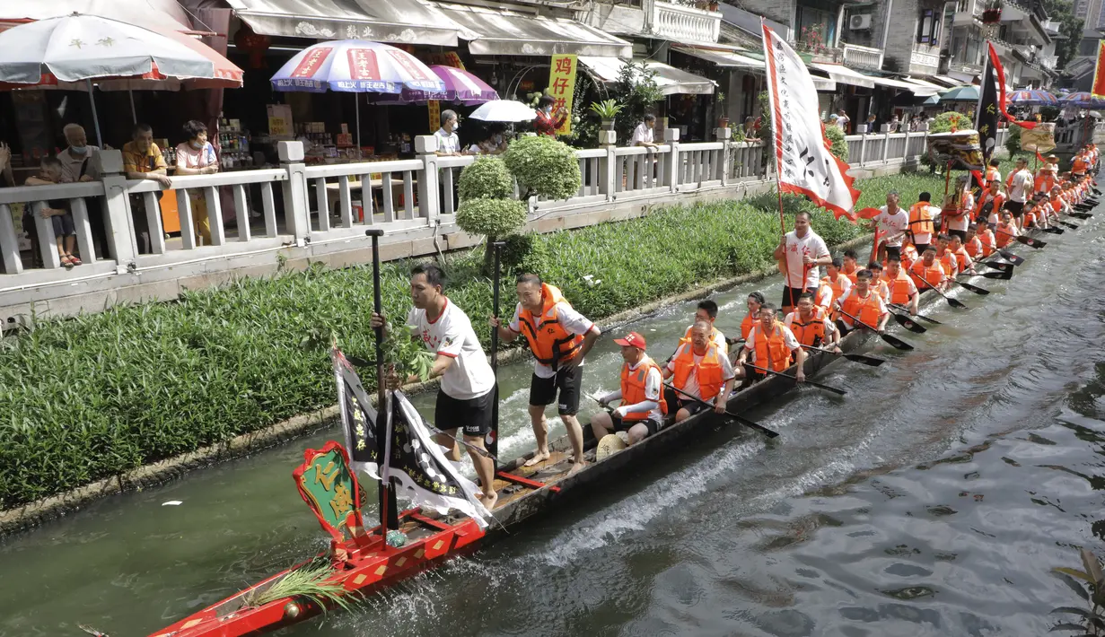 Peserta perahu naga dari desa Panting mendayung di sepanjang kanal di kawasan bersejarah Teluk Lychee di Guangzhou di Provinsi Guangdong, China selatan, Jumat, 3 Juni 2022. Perlombaan perahu naga kembali digelar di beberapa bagian China untuk pertama kalinya sejak merebaknya pandemi pada akhir 2019, saat pembatasan dicabut bersama dengan penurunan besar  kasus COVID-19. (AP Photo/Caroline Chen)