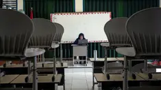 Guru sekolah dasar Eli Triana, 43, mengajar siswanya secara daring karena memburuknya kualitas udara akibat kebakaran hutan di Palembang, Sumatera Selatan, Kamis (5/10/2023). Sekolah daring mulai diberlakukan untuk pelajar di Palembang mulai Senin, 2 Oktober 2023. (Al ZULKIFLI/AFP)