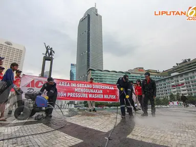 Puluhan petugas membersihkan kolam Bundaran HI, Jakarta, Sabtu (19/4/14). (Liputan6.com/Faizal Fanani)