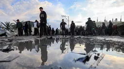 Sebelum serangan, militer Israel mengklaim telah mengeluarkan perintah evakuasi untuk area tersebut. Tampak dalam foto, warga memeriksa kerusakan akibat udara Israel menghantam sebuah lokasi dekat tenda-tenda penampungan pengungsi Palestina di Deir el-Balah, Jalur Gaza tengah pada 25 Maret 2026. (Eyad Baba/AFP)