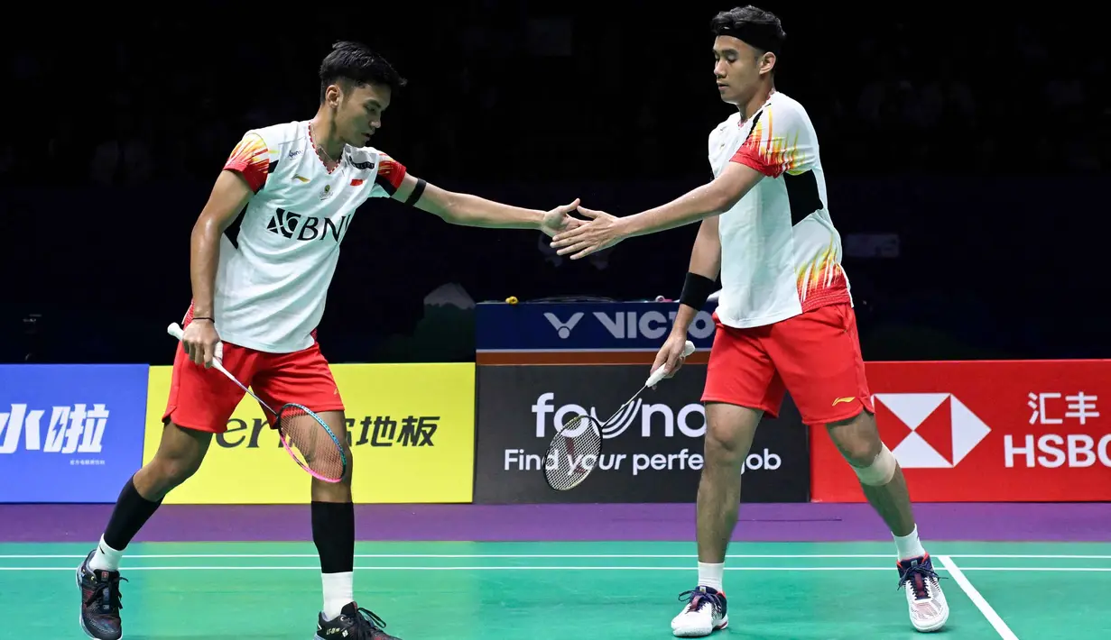 Pebulu tangkis Indonesia, Muhammad Shohibul Fikri (kiri) dan Bagas Maulana bereaksi setelah memenangkan satu poin melawan Kang Min-Hyuk dan Set Seung Jae dari Korea Selatan dalam perempat final ganda putra turnamen bulu tangkis Piala Thomas dan Uber di Chengdu, provinsi Sichuan, Tiongkok pada 3 Mei 2024. (WANG Zhao/AFP)