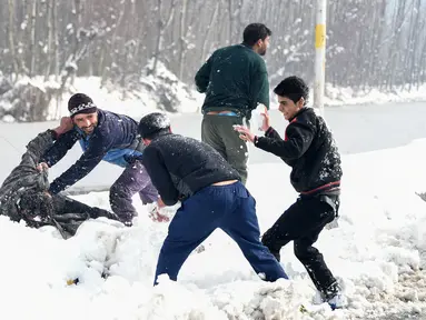 Pemuda Kashmir bermain dengan salju di tepi Danau Dal setelah salju turun di Srinagar, India bagian utara, Sabtu (5/1). Wilayah Kashmir mengalami salju selama beberapa hari yang mengakibatkan terputus jalan raya Jammu-Srinagar. (TAUSEEF MUSTAFA/AFP)