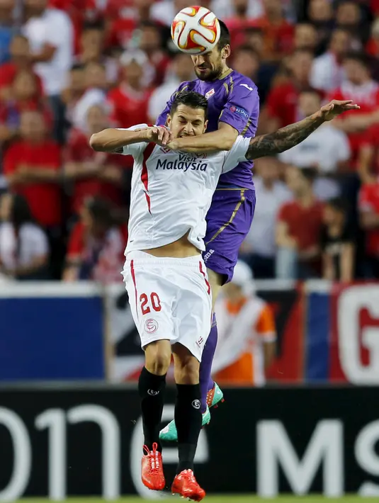 Gelandang Sevilla, Machin Vitolo (depan) berebut bola udara dengan bek Fiorentina Nenad Tomovic pada leg pertama semifinal Europa League di Stadion Ramon Sanchez, Kamis (7/5/2015). Sevilla menang 3-0 atas Fiorentina. (REUTERS/Marcelo del Pozo)