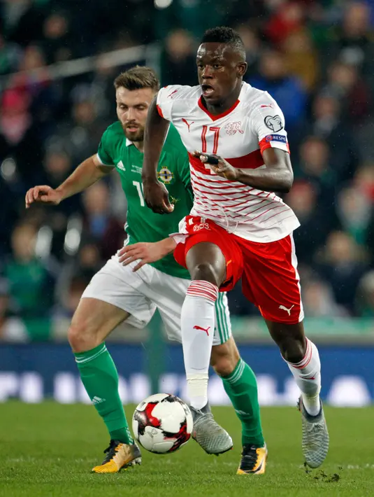 Pemain Swiss, Denis Zakaria berlari mengejar bola selama leg pertama playoff Piala Dunia 2018 di kandang Irlandia Utara, Windsor Park, Jumat (10/11). Bermain di kandang lawan, Swiss meraih kemenangan tipis 1-0. (AP/Peter Morrison)