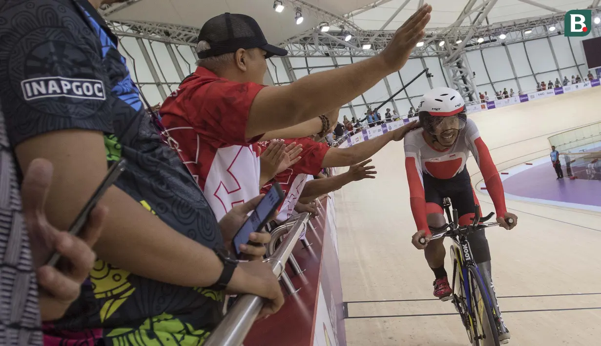 Selebrasi M Fadli pebalap sepeda Indonesia yang meraih medali emas di nomor 4000 meter Individual Pursuit C4 di Velodrome Rawamangun, Jakarta,  Jumat (11/10/2018).  (Bola.com/Peksi Cahyo)