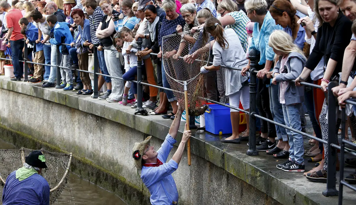 Seorang Nelayan saat mendapatkan ikan saat hari nelayan di Memmingen, Jerman, Sabtu (25/7/2015). Peserta yang menangkap ikan terbesar akan diberi nama "Raja Nelayan" selama satu tahun. (REUTERS/Michaela Rehle)