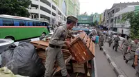 Barang-barang dari PKL diangkut Satpol PP di Pasar Tanah Abang, Jakarta, Kamis (4/5). Penertiban dilakukan agar tidak menggangu fungsi pedestrian untuk pejalan kaki. (Liputan6.com/Johan Tallo)