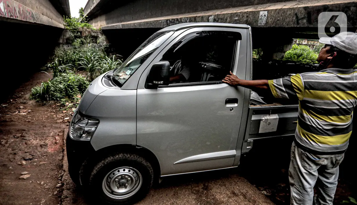 Pengendara mobil melintas di kolong Tol Jagorawi, Cimanggis, Depok, Jawa Barat, Minggu (8/11/2020). Buruknya jalan dan minimnya penerangan membuat akses tersebut rawan aksi kejahatan. (Liputan6.com/Faizal Fanani)