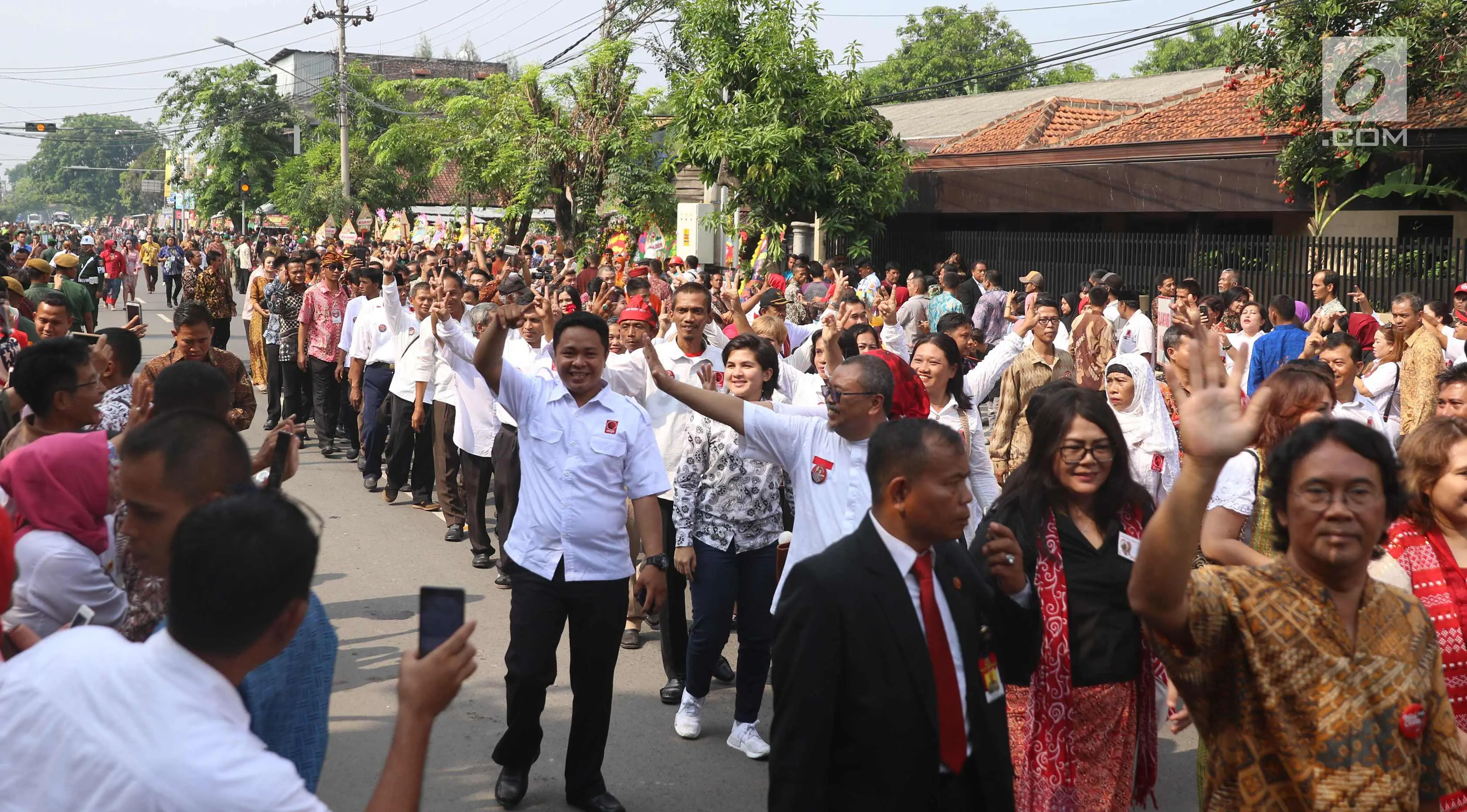 Sejumlah relawan menyaksikan prosesi kirab kereta kencana pernikahan putri Presiden Jokowi, Kahiyang Ayu-Bobby Nasution saat menuju Gedung Graha Saba di Surakarta, Rabu (8/11). (Liputan6.com/Angga Yuniar)