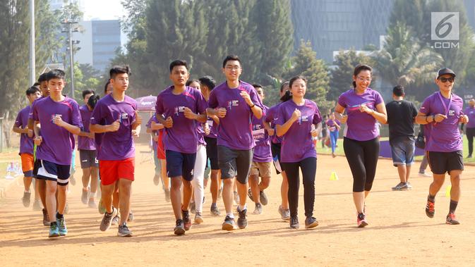 Head of Corcomm & Community Development Combiphar Dewinta Hutagaol (kedua kanan) dan peserta berlari mengelilingi lapangan dalam Coaching Clinic di Stadion Soemantri Brodjonegoro, Jakarta, Sabtu (28/7). (Liputan6.com/Fery Pradolo)