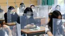 Siswa menunggu kelas dimulai dengan pembatas plastik di atas meja di Jeonmin High School di Daejeon, Korea Selatan, Rabu (20/5/2020). Hingga kini, Korea Selatan memiliki 11.110 kasus corona dengan 263 kematian dan 10.066 pasien sembuh. (Kim Jun-beom/Yonhap via AP)