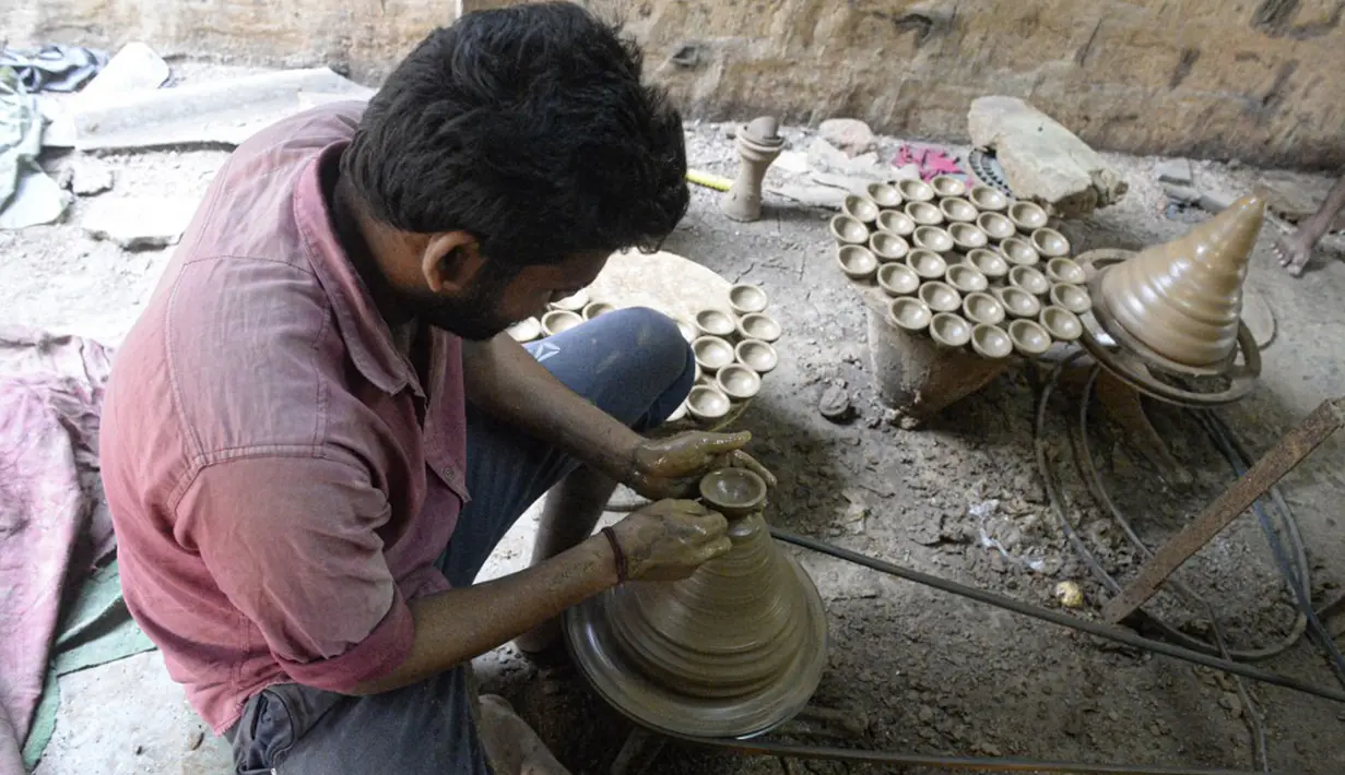 Seorang perajin tembikar membuat diyas atau pot minyak jelang Festival Diwali di pinggiran Hyderabad, India, 26 Oktober 2021. Diwali adalah salah satu festival besar yang dirayakan oleh umat Hindu, Jain, Sikh dan beberapa umat Buddha, terutama umat Buddha Newar. (NOAH SEELAM/AFP)