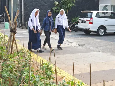 Pelajar melintasi trotoar di kawasan Kemang, Jakarta, Selasa (15/10/2019). Pemerintah Provinsi DKI menargetkan pelebaran dan penataan trotoar ini akan rampung pada Desember 2019. (Liputan6.com/Herman Zakharia)
