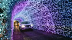 Mobil melewati terowongan cahaya dalam acara drive-thru "WinterLights" di Pacific National Exhibition, Vancouver, British Columbia, Kanada, 12 Desember 2020. Acara ini menyuguhkan berbagai instalasi cahaya, karakter, pertunjukan langsung, kuliner, serta lagu-lagu Natal. (Xinhua/Liang Sen)