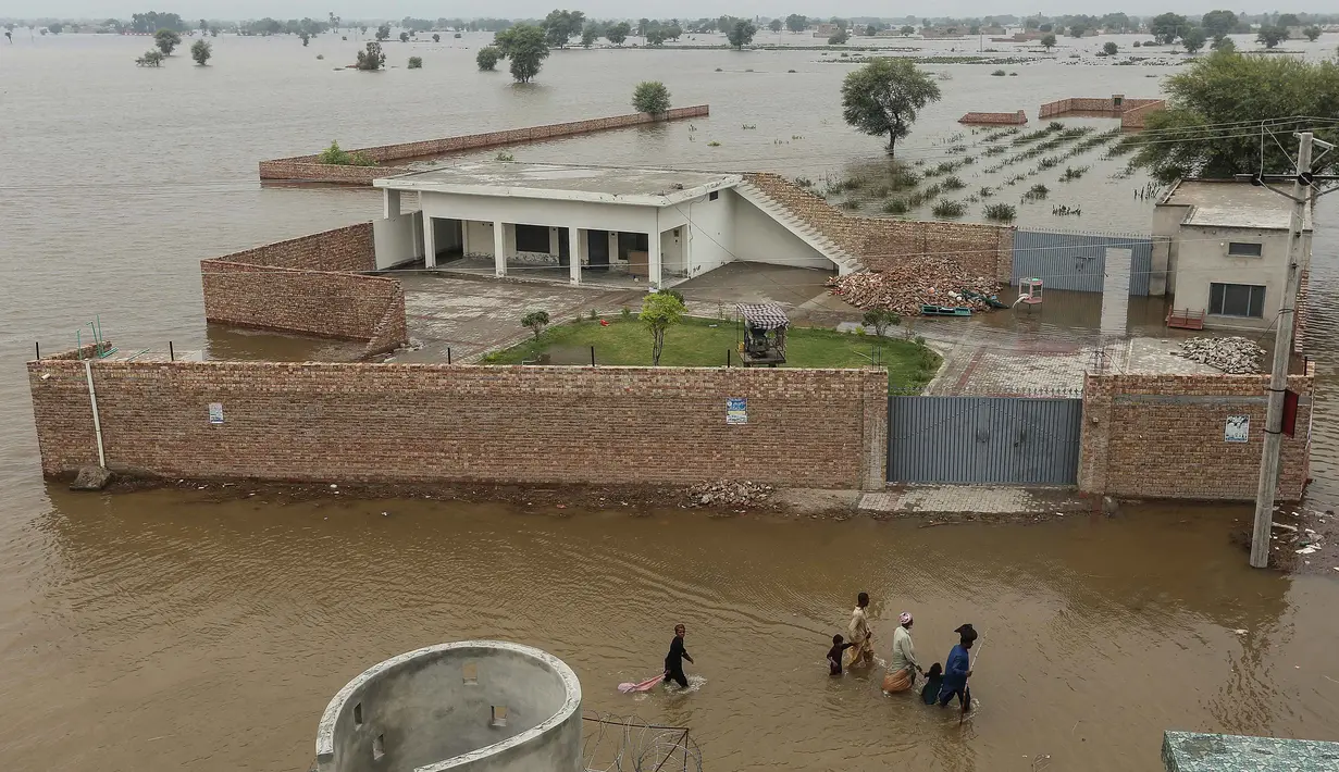 Warga desa yang terdampak banjir dengan perahu di Jalalpur Pirwala, distrik Multan, provinsi Punjab, pada 8 September 2025 menyusul luapan Sungai Chenab akibat hujan muson yang deras. (Shahid Saeed MIRZA/AFP)