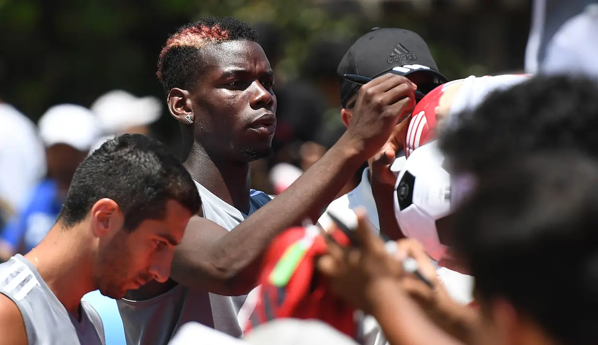 Gelandang Manchester United, Paul Pogba, melayani permintaan tanda tangan fans usai latihan di Universitas California, AS, Jumat (14/7/2017). Skuad Setan Merah akan tampil di turnamen pramusim bertajuk International Champions Cup. (AFP/Robyn Beck)