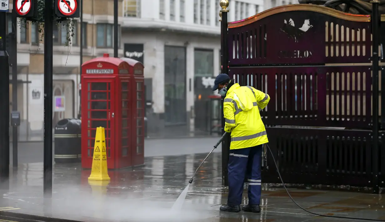 Seorang pekerja membersihkan jalan dekat Leicester Square, London, Inggris, 21 Desember 2020. Menteri Kesehatan Inggris Matt Hancock mendesak warga Inggris untuk berperilaku seolah-olah mereka sudah terjangkit virus corona COVID-19. (Xinhua/Han Yan)