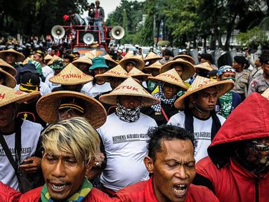 Massa yang mengatasnamakan petani dari berbagai provinsi mengenakan topi caping saat menggelar demonstrasi di kawasan Medan Merdeka, Jakarta, Selasa (27/9). Aksi tersebut digelar dalam rangka memperingati Hari Tani Nasional. (Liputan6.com/Faizal Fanani)