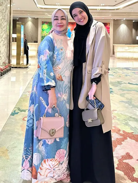 Hadiri fashion show, Dhini Aminarti padukan kemeja lengan panjang dan rok loose panjang. Outfit serba hitam ini dilapisi outer dan tas tangan cokelat [@dhiniaminarti]