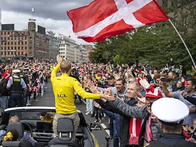 Pembalap tim Jumbo-Visma, Jonas Vingegaard menyapa para penggemar dari mobil di Kopenhagen, Denmark pada 27 Juli 2022, beberapa hari setelah menjuarai balapan sepeda Tour de France 2022 di Paris. (AFP/Ritzau Scanpix/Thomas Sjoerup)