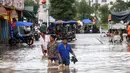 Sejumlah warga melintasi banjir di kawasan Loudi, provinsi Hunan (2/7). Curah hujan yang tinggi membuat air sungai Xiangjiang meluap dan mengakibatkan banjir di provinsi Hunan. (AFP Photo/Str/China Out)