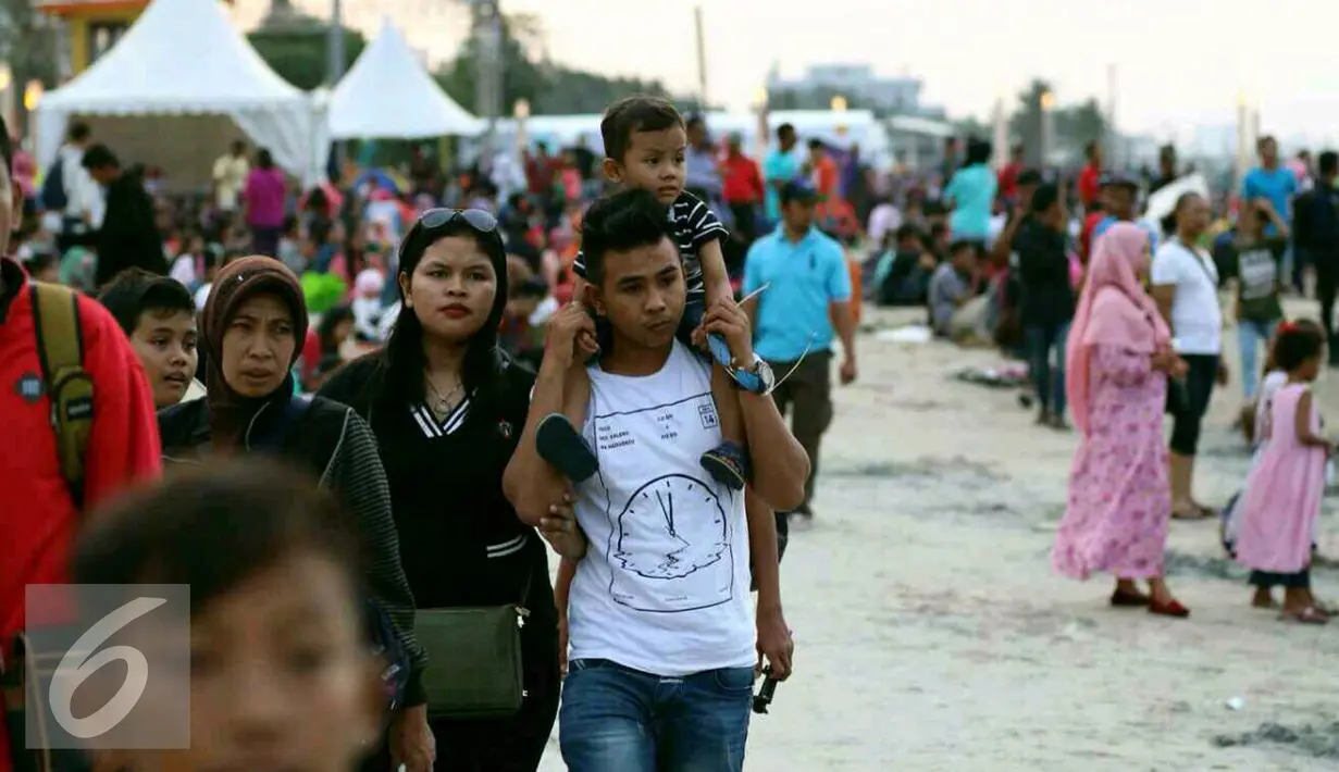Sejumlah keluarga beserta anak-anaknya memadati kawasan pantai Ancol untuk menunggu pergantian tahun baru, Jakarta, Sabtu (31/12). (Liputan6.com/Angga Yuniar