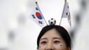 Bukan hanya cantik, mereka juga tampil unik dengan menaruh bendera dan bola kecil dikepala agar menjadi pusat perhatian. (AP Photo/Lee Jin-man)