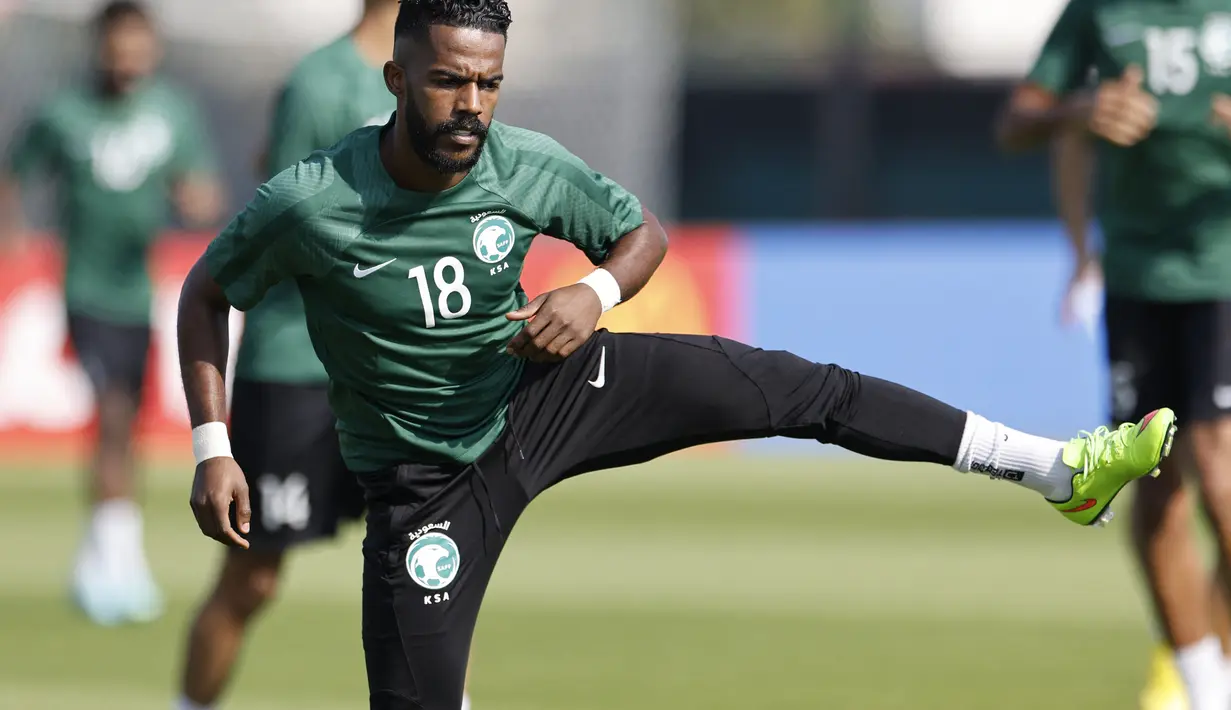 Gelandang Arab Saudi, Nawaf Al-Abed melakukan pemanasan saat mengikuti sesi latihan di Situs Pelatihan Sealine di Sealine, selatan Doha (21/11/2022). Arab Saudi akan bertanding melawan Argentina pada grup C Piala Dunia 2022 Qatar. (AFP/Khaled Desouki)