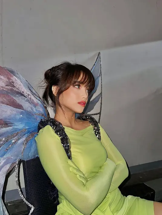 Fuji menjelma sebagai Tinkerbell dengan outfit hijau, lengkap dengan sayapnya. Penampilannya semakin sempurna dengan makeup bold bernuansa kemerahan. [Foto: Instagram/fuji_an]