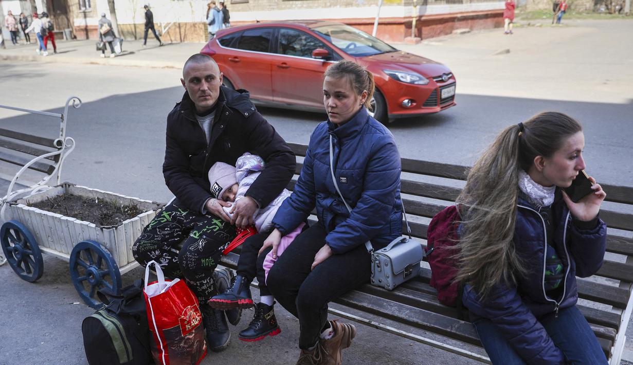 Korban selamat duduk di bangku di luar stasiun setelah serangan roket di stasiun kereta api di kota timur Kramatorsk, di wilayah Donbass (8/4/2022). Sekitar 50 orang tewas dan lebih dari 100 terluka dalam serangan roket di stasiun kereta api kata kepala perusahaan kereta api. (AFP/Anatolii Stepanov)