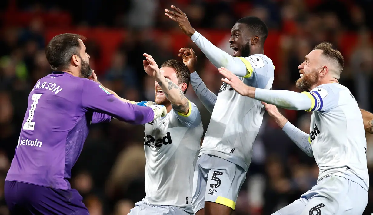 Penjaga gawang Derby County, Scott Carson (kiri) bersama rekan setimnya merayakan kemenangan usai menyingkirkan Manchester United di Piala Liga Inggris di Old Trafford, Manchester, Inggris, Selasa (25/9). (Martin Rickett/PA via AP)