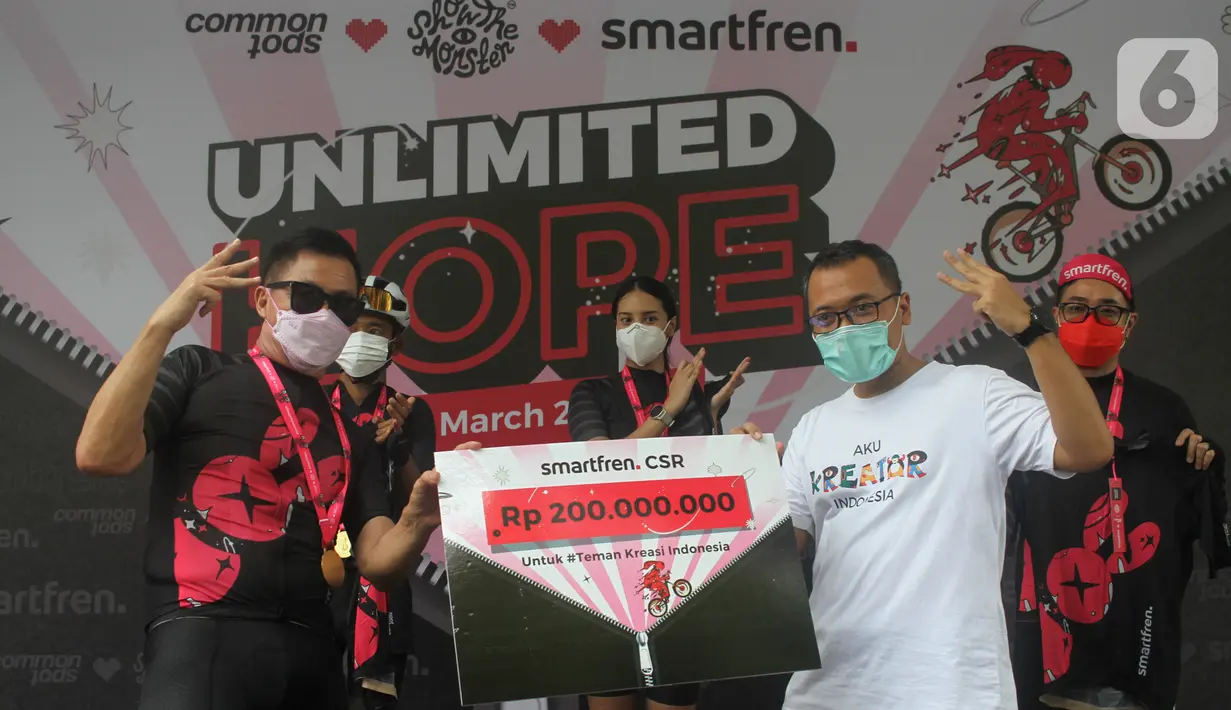 Deputy CEO Smartfren Djoko Tata Ibrahim memberikan dana CSR untuk pemberdayaan UMKM senilai Rp200 juta melalui Teman Kreasi Indonesia pada peluncuran jersey bersepeda Unlimited Hope hasil kokreasi Smartfren, Show The Monster dan Common Spot di Jakarta, Sabtu (27/3/2021). (Liputan6.com/Pool)