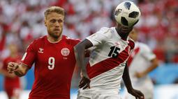 Bek Peru, Christian Ramos, berebut bola dengan striker Denmark, Nicolai Jorgensen, pada laga Grup C Piala Dunia di Mordovia Arena, Saransk, Sabtu (16/6/2018). Denmark menang 1-0 atas Peru. (AP/Efrem Lukatsky)