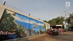 Anak-anak bermain di sekitar mural Betawi di Kampung Pitung, Marunda, Jakarta, Senin (2/7). Mural yang dibuat sejak sebulan lalu ini merupakan goresan tangan warga lokal. (Merdeka.com/Iqbal S. Nugroho)