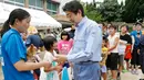 PM Jepang, Shinzo Abe berbincang dengan anak-anak korban banjir di lokasi penampungan di Kurashiki, Prefektur Okayama, Rabu (11/7). Pemerintah menyebut bencana alam ini merupakan yang terburuk dalam tiga dekade terakhir. (Shohei Miyano/Kyodo News via AP)