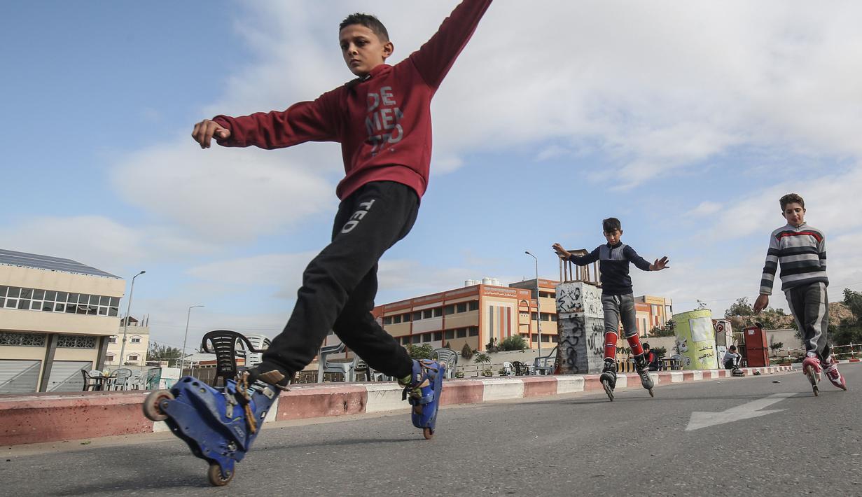 Pemuda Palestina melakukan gaya bebas saat bermain sepatu roda dijalanan kawasan Khan Younis, Jalur Gaza, Selasa (19/1/2021). (AFP/Said Khatib)