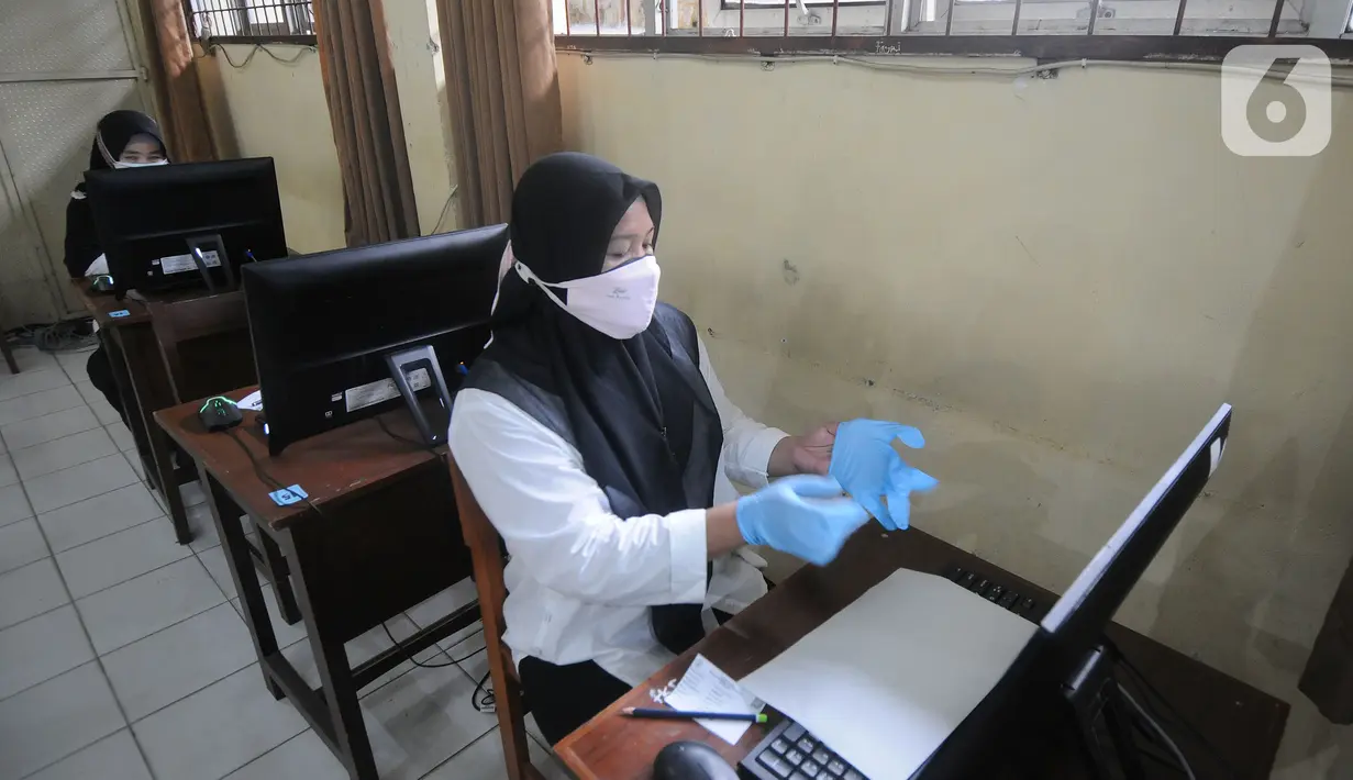 Peserta memakai sarung tangan sebelum pelaksanaan ujian seleksi kompetensi P3K Guru di SMKN 2, Depok, Jawa Barat, Selasa (14/9/2021). Kemendikbud mulai Senin (13/9) secara serentak di Indonesia dilaksanakan ujian Seleksi Kompetensi P3K di 1000 lokasi. (merdeka.com/Arie Basuki)