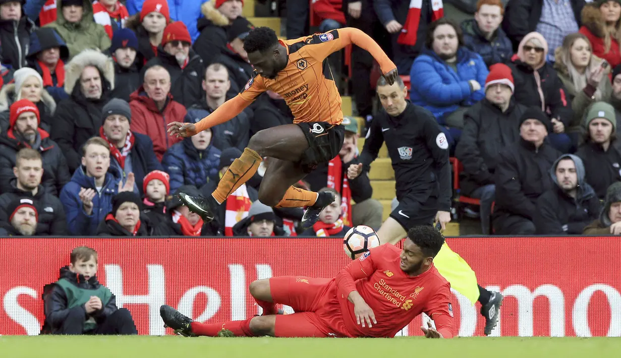 Aksi pemain Wolverhampton Wanderers, Nouha Dicko jmelompat menghindari terjangan pemain Liverpool,  Joe Gomez pada laga Piala FA putaran keempat di Anfield, Liverpool (28/1/2017). Liverpoool kalah 1-2. (Peter Byrne/PA via AP)