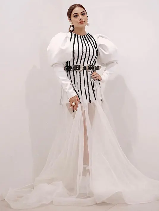 Saat tampil di layar kaca atau bernyanyi di atas panggung, Aurel selalu tampil memukau. Penampilannya memakai gaun putih dengan aksen garis hitam ini terlihat makin memesona. Banyak yang memuji istri Atta ini kian cantik. (Liputan6.com/IG/@aurelie.hermansyah)