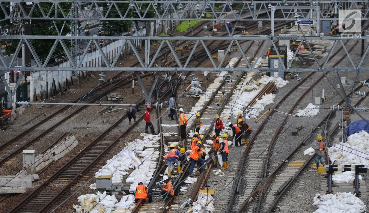 Aktivitas pekerja di jalur dwiganda atau double-double track (DDT) kawasan Jatinegara, Jakarta, Jumat (12/4). DDT segmen Jatinegara-Cakung mulai digunakan pada hari ini. (Liputan6.com/Herman Zakharia)