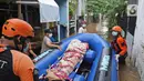 Relawan dan keluarga membawa jenazah warga lansia dengan perahu karet saat banjir di kawasan Cipinang Melayu, Jakarta Timur, Jumat (19/2/2021). Seorang nenek (80) meninggal di kediamannya, di lokasi banjir, di RW 04, kawasan tersebut karena sakit dan sudah lanjut usia. (Liputan6.com/Herman Zakharia)