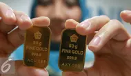 Seorang teller menunjukan emas batangan di Jakarta, Selasa (15/11). Harga emas batangan atau Logam Mulia milik PT Aneka Tambang Tbk (Antam) hari ini dibuka turun Rp 2.000/gram. (Liputan6.com/Angga Yuniar)