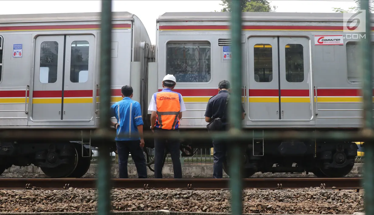 Sejumlah petugas KAI memeriksa keadaan kereta yang anjlok di dekat Stasiun Palmerah, Jakarta, Sabtu (13/10). Para penumpang terpaksa turun dan sebagian memutuskan berganti kereta karena KRL tak dapat melanjutkan perjalanan. (Liputan6.com/Herman Zakharia)