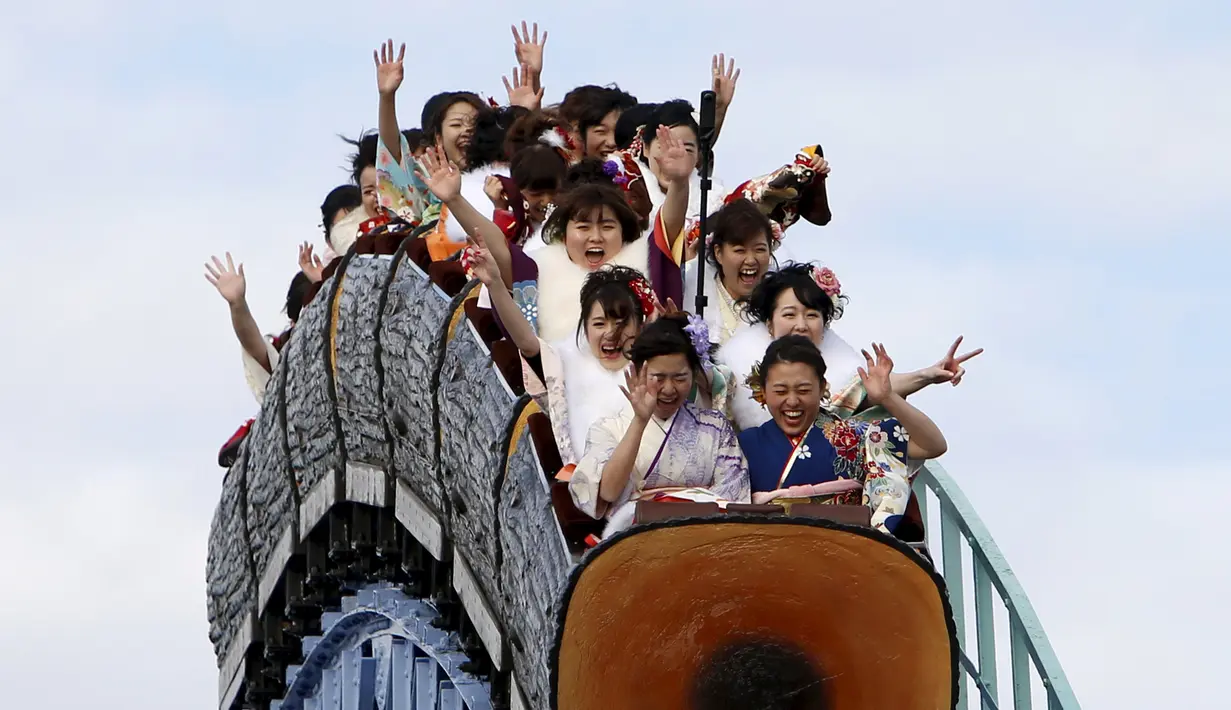 Wanita Jepang berpakaian kimono menaiki roller coaster di perayaan Coming of Age Day (Hari Kedewasaan Nasional) di taman hiburan Tokyo, Senin (11/1). Hari Kedewasaan Nasional ini dirayakan para muda-mudi yang menginjak usia 20 tahun. (REUTERS/Yuya Shino)