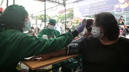 Tenaga kesehatan memeriksa kesehatan warga calon penerima vaksin COVID-19 dosis ketiga di Puskesmas Kecamatan Kramat Jati, Jakarta, Rabu (12/1/2022). Program booster COVID-19 diberikan kepada kelompok prioritas yaitu lanjut usia (lansia) dan penderita immunokompromais. (Liputan6.com/Faizal Fanani)