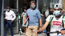 Orang-orang memakai masker saat berjalan di Brussel, Belgia, Rabu (12/8/2020). Penggunaan masker menjadi wajib di tempat umum di Brussel karena kasus Covid-19 naik ke tingkat kewaspadaan yang menempatkan kota itu di antara yang paling parah terkena dampak corona di Eropa. (François WALSCHAERTS/AFP)