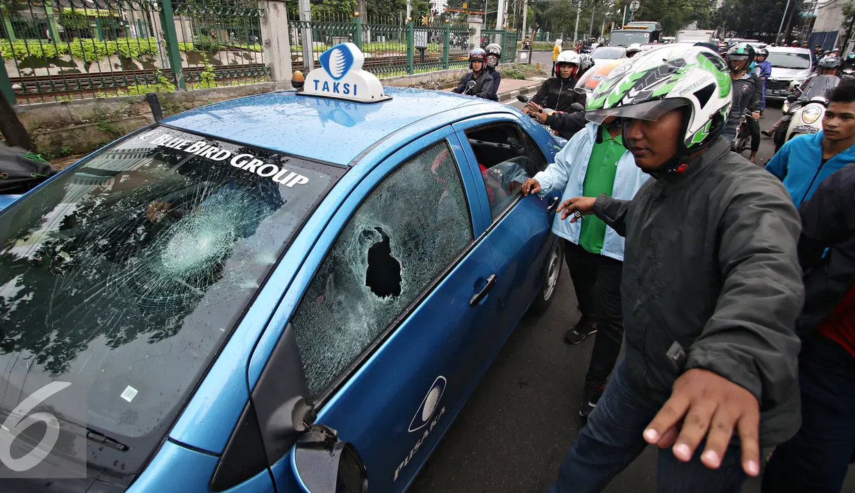 Pengendara ojek online merusak dan melakukan sweeping di kawasan Senayan, Jakarta, Selasa (22/3). Pascabentrok ojek online melakukan sweeping dan perusakan terhadap taksi serta bajaj yang melintas di kawasan tersebut. (Liputan6.com/Immanuel Antonius)